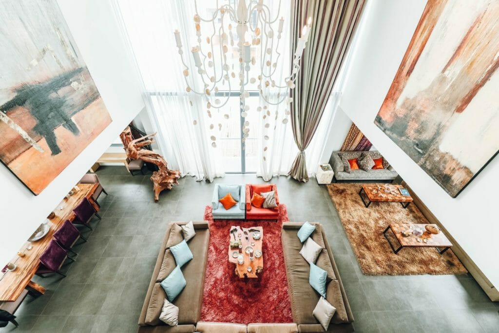 Living room with throw pillows, rugs, sofas, velvet chairs, and wood furniture